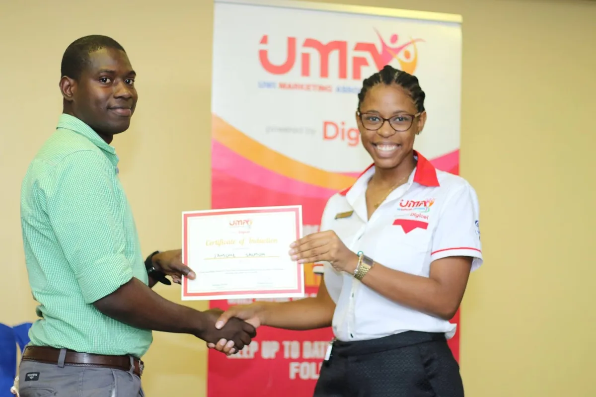 Jahmone receiving a certificate of induction from the UWI Marketing Association