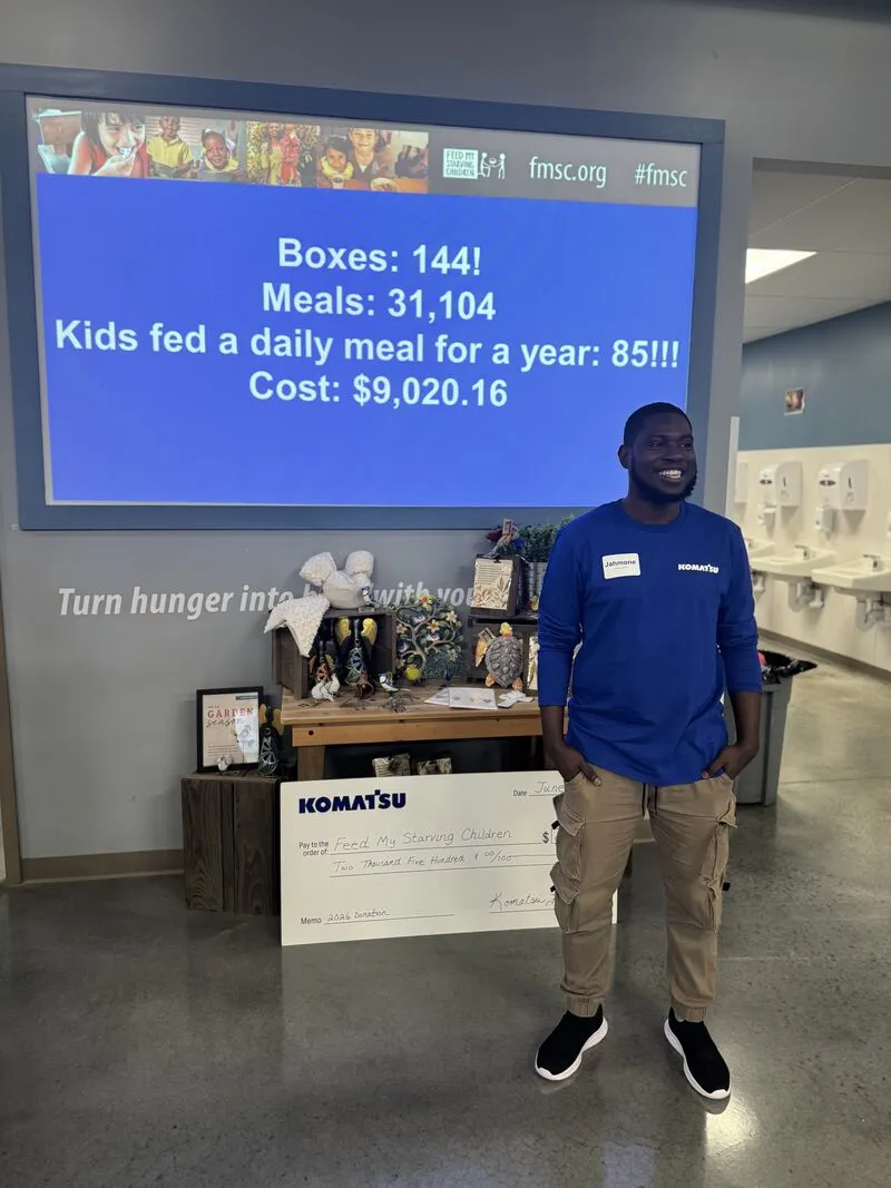 Jahmone beside the results screen: 144 boxes, 31,104 meals, 85 kids fed for a year