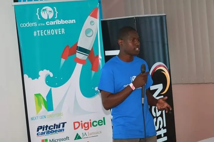 Jahmone speaking with a microphone at Coders of the Caribbean Techover